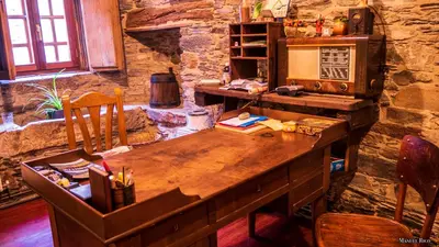 a wooden desk in a room with a stone wall at Cabeza da Vila in San Martín de Oscos