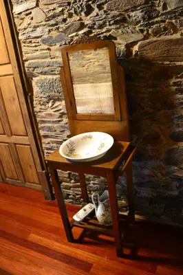 a plate on a stand next to a chair at Cabeza da Vila in San Martín de Oscos