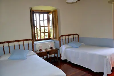 a bedroom with two beds and a window at Cabeza da Vila in San Martín de Oscos