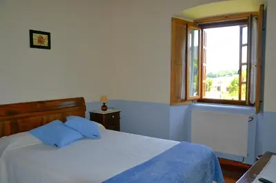 a bedroom with a large bed and a window at Cabeza da Vila in San Martín de Oscos