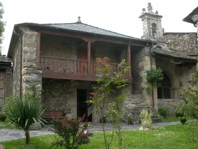 an old stone building with a balcony on it at Casa de Alba in San Martín de Oscos