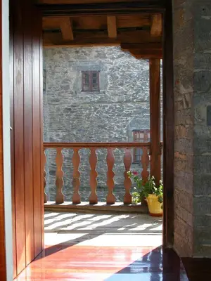 an open door to a balcony with a stone wall at Casa de Alba in San Martín de Oscos