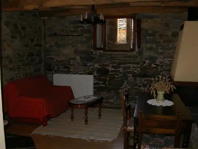 a living room with a red couch and a table at Casa de Alba in San Martín de Oscos