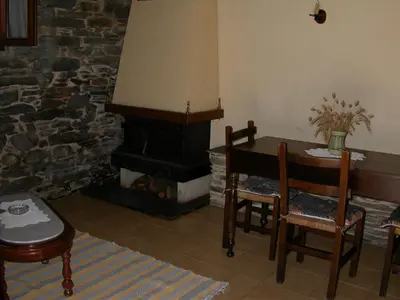 a living room with a table and a fireplace at Casa de Alba in San Martín de Oscos