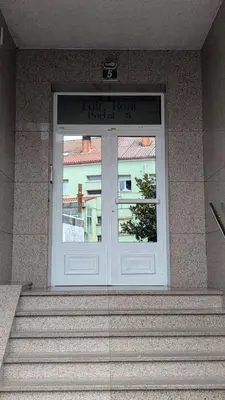 a front door of a building with stairs in front at Alojamiento Camiño Real in Sigüeiro