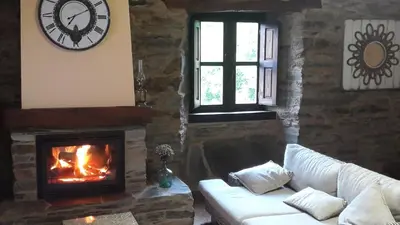 a living room with a fireplace and a white couch at O Paxar in Samos
