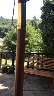 a pole next to a wooden bench in a park at O Paxar in Samos