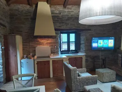 a kitchen with a refrigerator and a tv at O Paxar in Samos