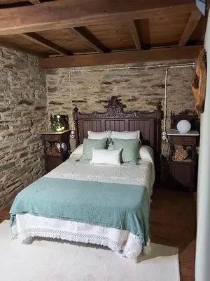 a bedroom with a bed with a stone wall at O Paxar in Samos