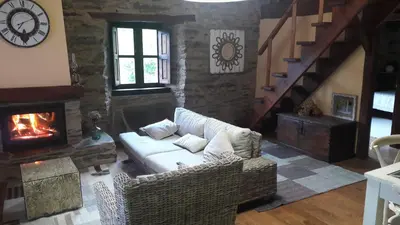 a living room with a couch and a fireplace at O Paxar in Samos