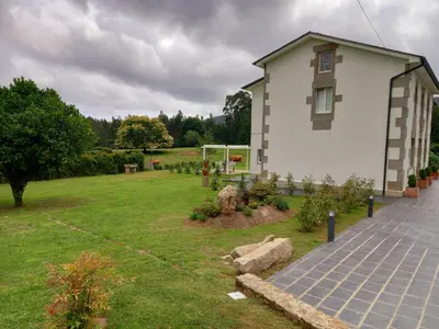a house with a grass yard with a building at O Rincón de Mercedes in Jove