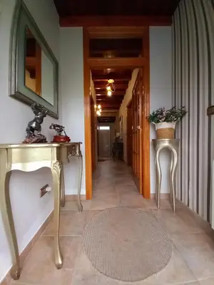 a hallway with two tables and a mirror and a rug at O Rincón de Mercedes in Jove