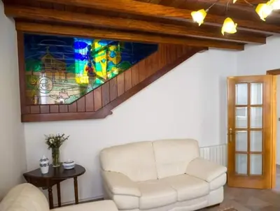 a living room with a white couch and a stained glass window at O Rincón de Mercedes in Jove