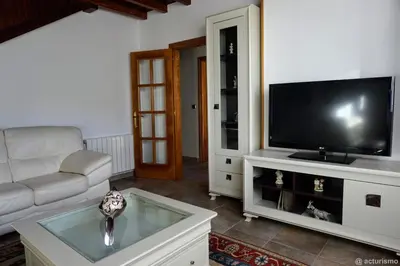 a living room with a couch and a tv at O Rincón de Mercedes in Jove
