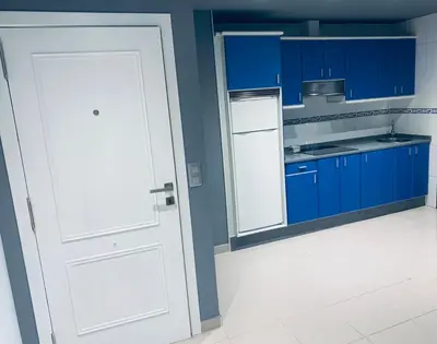 a kitchen with blue cabinets and a white door at lucushouse II in Lugo