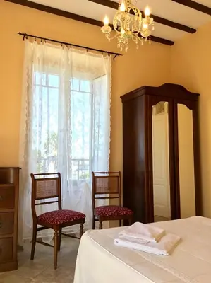 a bedroom with a bed and two chairs and a window at Villa Auristela in Navia