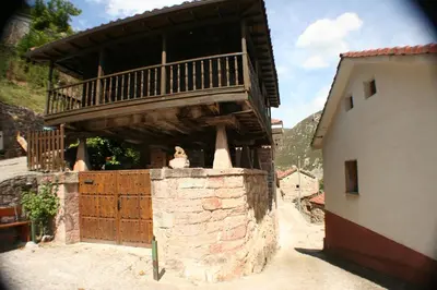a building with a balcony on top of a wall at zentralclub apartamento El Nido de Somiedo in Santiago del Hermo