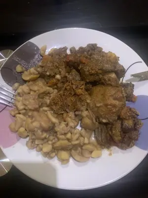 a plate of food with meat and beans on a table at Hotel rural casa Ferreiro in Seoane