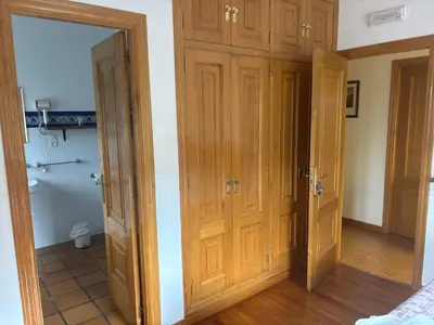 a room with wooden doors and a bathroom at Hotel rural casa Ferreiro in Seoane