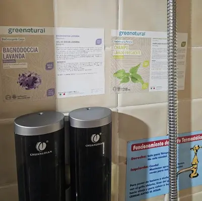 two trash cans are next to a wall with signs at Casa Rural La Pumarada de Limés in Cangas del Narcea