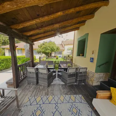 a patio with a table and chairs on a deck at Casa Rural La Pumarada de Limés in Cangas del Narcea