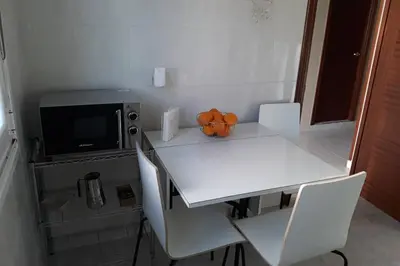 a kitchen with a white table and a microwave at Casa IRIENSE VUT-CO-004308 in Padrón