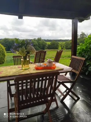 a wooden table with four chairs on a patio at Casa Crisanta in Lomba