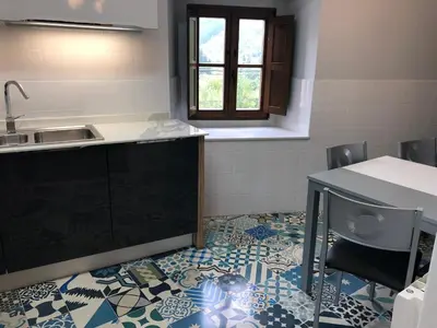 a kitchen with a sink and a tile floor at La Capilla del Corral in Cangas del Narcea