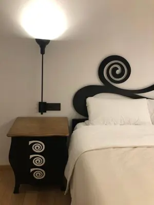 a bedroom with a bed with a black and white headboard at La Capilla del Corral in Cangas del Narcea