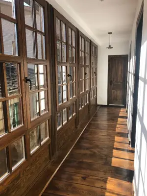 a hallway with wooden doors and windows in a building at La Capilla del Corral in Cangas del Narcea