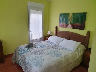 a bedroom with a bed with a painting on the wall at Casa César in Barreiros