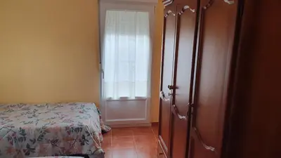 a bedroom with a bed and a door with a window at Casa César in Barreiros
