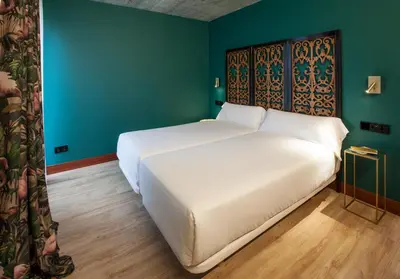 a large white bed in a room with green walls at Eira Gundián in Vedra