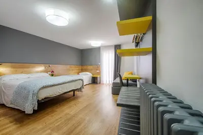 a hotel room with two beds and a couch at Hostal-Restaurante LUGANO in Verín