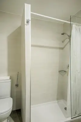 a bathroom with a shower and a toilet at Hostal-Restaurante LUGANO in Verín