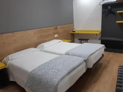 two beds sitting next to each other in a room at Hostal-Restaurante LUGANO in Verín