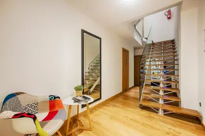 a room with a staircase and a chair and a table at Hostal-Restaurante LUGANO in Verín