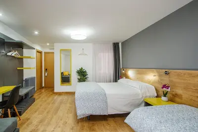 a hotel room with a bed and a desk at Hostal-Restaurante LUGANO in Verín