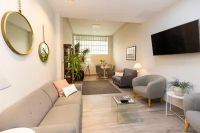 a living room with a couch and a mirror at Hotel Ros Mary in Ribadeo