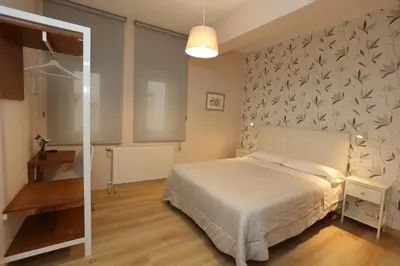 a bedroom with a white bed and a wall at Hotel Ros Mary in Ribadeo
