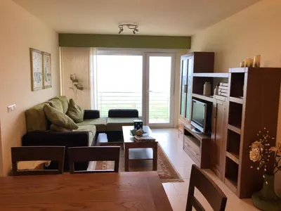 a living room with a couch and a tv at Apartamento Playa San Pedro in Barreiros