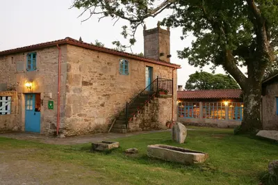an old stone building with a tree in front of it at A Parada Das Bestas in Pidre