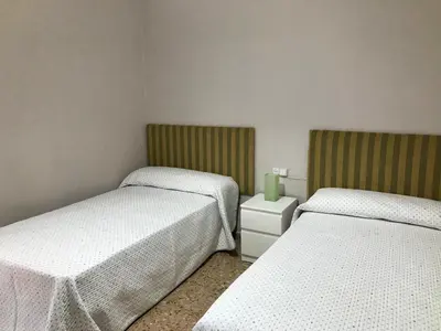 two beds in a room with white sheets at Casa de la Abuela in Fabero