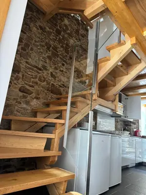 a staircase in a kitchen with a stone wall at Casa Alameda 23 de Casas Das Figueiras en Ría Eo-Ribadeo in Castropol