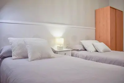 a bedroom with two beds with white pillows at Lucus Dúplex in Lugo