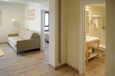 a kitchen and living room with a table and a couch at APARTAMENTOS TURÍSTICOS GUIANA in Ponferrada