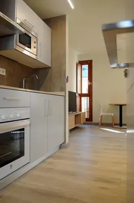 a bedroom with a desk and a television on the wall at APARTAMENTOS TURÍSTICOS GUIANA in Ponferrada