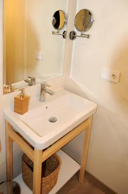 a room with a bed and a desk with a tv on the wall at APARTAMENTOS TURÍSTICOS GUIANA in Ponferrada