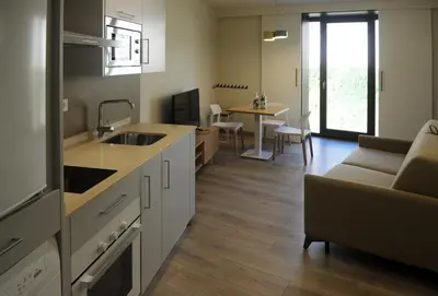 a kitchen and living room with a couch and a table at APARTAMENTOS TURÍSTICOS GUIANA in Ponferrada