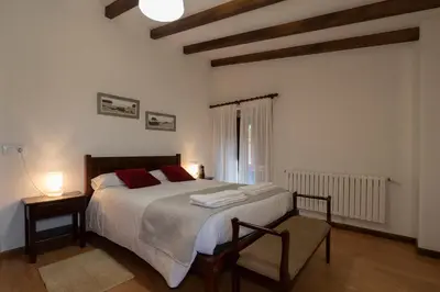 a bedroom with a large bed and a window at Casa rural completa Río Sarela in Santiago de Compostela